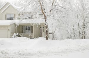 white-house-in-winter-landscape-with-snow-and-ice-in-yard-and-trees