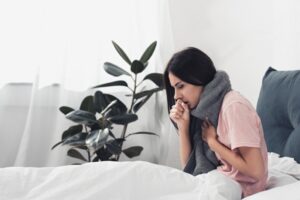 woman-sitting-up-in-bed-coughing